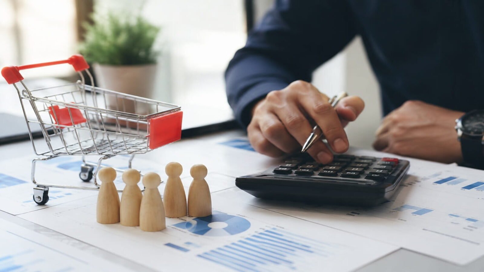 Business professional calculating Customer Acquisition Cost using financial reports, analytics dashboard, calculator, and customer acquisition data.